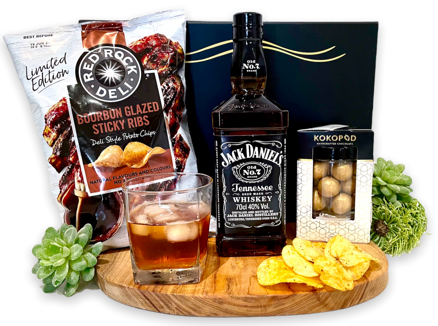 Surprise someone you love with of bottle of their favourite, Jack Daniels Tennessee Whiskey. To enjoy and saviour over rocks or straight. With the added crunch of Red Rock's Limited Edition Bourbon glazed sticky rib Chips for the savoury senses and Caramelised Macadamias for the sweet tooth.