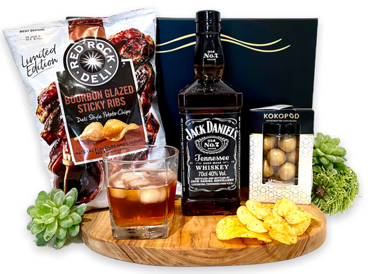 Surprise someone you love with of bottle of their favourite, Jack Daniels Tennessee Whiskey. To enjoy and saviour over rocks or straight. With the added crunch of Red Rock's Limited Edition Bourbon glazed sticky rib Chips for the savoury senses and Caramelised Macadamias for the sweet tooth.